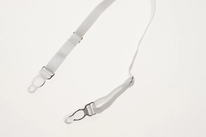 Detail of white elastic garter belt with adjustable metal buckle and secure leg clips