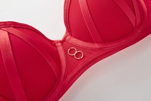 Close-up of red push-up bra with breathable mesh, satin straps and gold ring detail