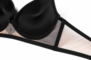 Détails macro des bonnets lisses et du tulle transparent sur ce soutien-gorge noir