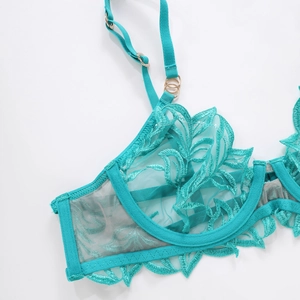 Close-up of teal floral lace embroidery on underwire bra with rose gold hardware