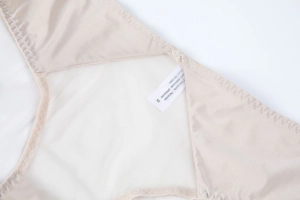 Detail of sheer honeycomb mesh and satin fabric with 100% cotton crotch on nude panty