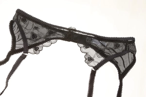 Detail of black lace garter belt with heart pattern embroidery and adjustable straps