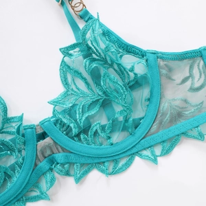 Detail of teal lace bra featuring floral embroidery and sheer mesh with supportive underwire