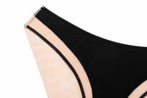 Gros plan sur les coutures contrastées du mesh et l'empiècement noir de ce slip sexy