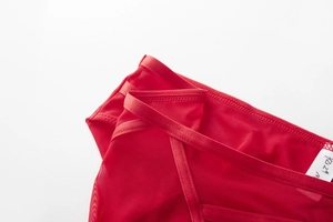 Close-up of red mesh bra detail with YZ12 code on size M white laundry label