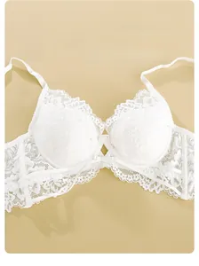 Dettaglio di reggiseno in pizzo bianco con ferretto morbido e fiocco decorativo in seta