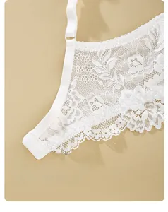 Dettaglio ravvicinato della delicata lavorazione in pizzo floreale bianco del reggiseno
