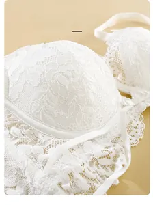 Dettaglio del reggiseno in pizzo bianco con delicati motivi floreali e tessuto morbido