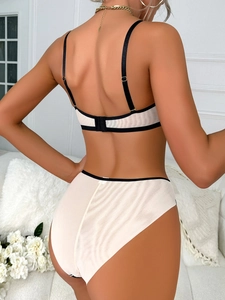 Vista posteriore di lingerie beige con bordi neri a contrasto e spalline regolabili