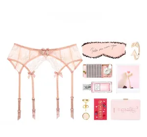 Detail of pink floral lace garter belt with silk bows and adjustable metal clips