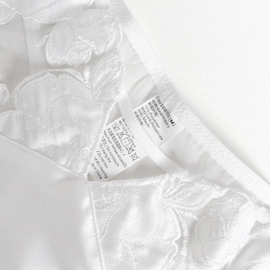 Close-up of lace lingerie care label showing size M and fabric composition details