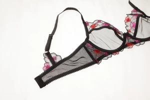 Détail de soutien-gorge en maille noire avec broderie de cœurs rouge et rose délicate
