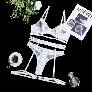 Detail of white lace lingerie set with mesh bra, waist cincher, and golden rings
