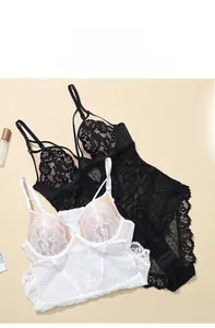 Close-up of deep V-neck lace bodysuit with floral embroidery and polka dot mesh detail