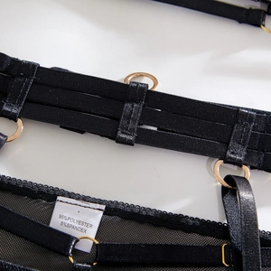 Detail of mesh fabric and elastic straps with gold rings and material label