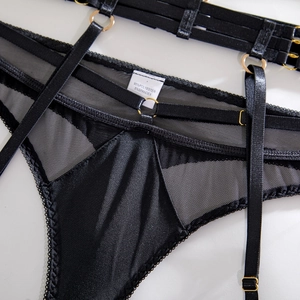 Detail of black lace mesh lingerie with gold metal rings and adjustable straps