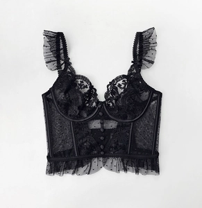 Detail of black lace bustier top featuring V-shape cups and delicate floral mesh texture
