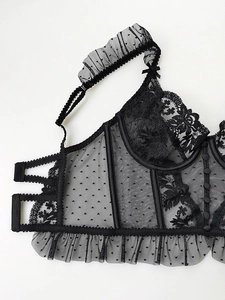 Detailed view of black lace bustier featuring polka dot mesh and vertical boning support