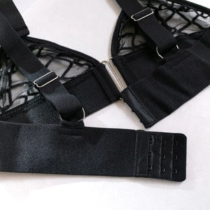 Detailed macro view of black lace lingerie showing the silk fabric and metallic strap rings