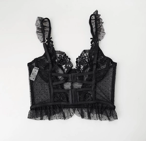 Detailed view of black lace bustier with floral embroidery and ruffle shoulder straps