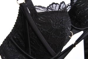 Detailed close-up of black floral lace and gold metal rings on a French-style bra