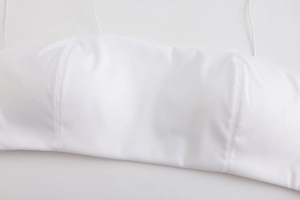 Close-up of white seamless wireless bralette with thin straps and vertical stitching
