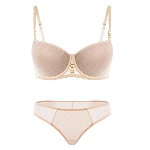 Detail of beige lingerie set with diamond quilted texture and gold ring accents