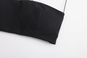 Macro shot of fine black seamless stitching and ultra-thin strap on smooth fabric