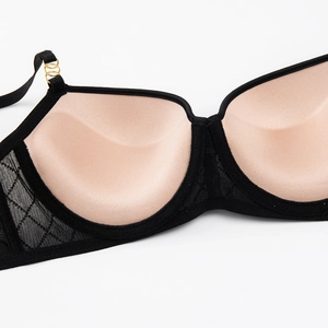 Close-up of black bra with pink lining and breathable diamond mesh side panels