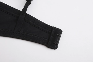 Détail de la bretelle de soutien-gorge noire avec crochets et coutures zigzag