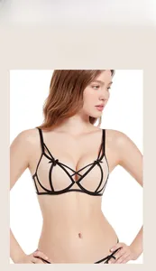 Detailed macro view of beige lace bra featuring elegant black geometric strappy overlays