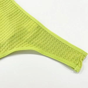 Detail view of neon green waffle knit fabric texture and high-quality seamless edge stitching