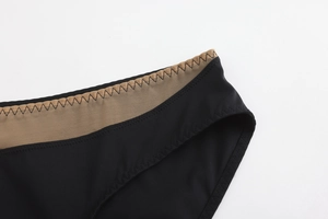 Detail view of black seamless lingerie with mesh patchwork and wave stitching accents