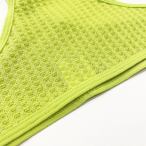 Close-up of breathable neon green mesh fabric with fine hexagonal holes and double stitching