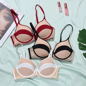 Détail de quatre soutiens-gorge sans couture rouges, noirs et blancs sur soie verte