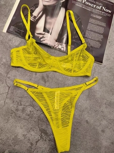 Flat lay of yellow sheer lace lingerie set with underwire bra and thin strap thong