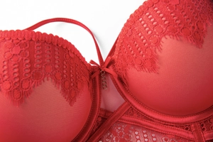 Close-up of red floral lace bra with delicate eyelash edges and metal chain detail