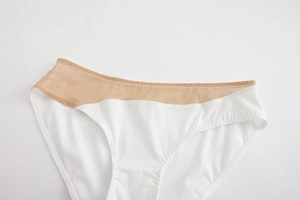 Detailed view of seamless white panties with mesh stitching and wavy embroidery details