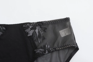 Détail du slip en dentelle noire avec broderie florale grise et coutures en maille fine