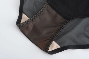Gros plan sur la culotte en dentelle noire avec mesh respirant et détail d'entrejambe en coton