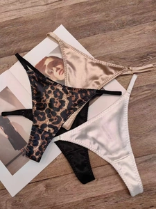 Quatre strings en satin : imprimé léopard, champagne, blanc et noir, posés à plat