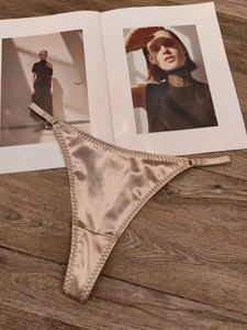 Vue détaillée du string en satin doré champagne avec de fines bretelles élastiques