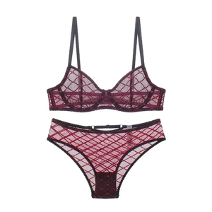 Close-up of wine red lace lingerie set with gold geometric grid patterns and mesh texture