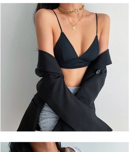 Détail d'une brassière noire minimaliste col en V avec blazer et collier chaîne dorée