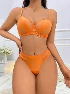 Detail of bright orange push-up bra and thong set with satin mesh patchwork and fine straps