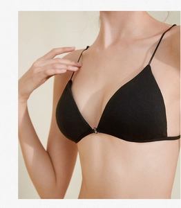 Détail d'un soutien-gorge triangle noir avec fines bretelles et boucle de fermeture avant