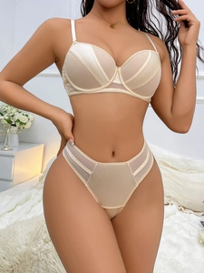 Detail of champagne satin and mesh lingerie set with supportive underwire on a model