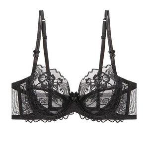 Close-up of black floral lace details with sheer mesh and bow accents on a bra