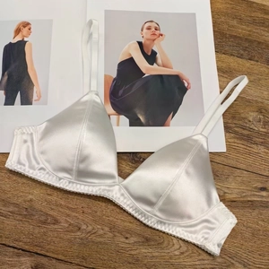 Close-up of white satin triangle bra with scalloped lace trim and silk texture finish
