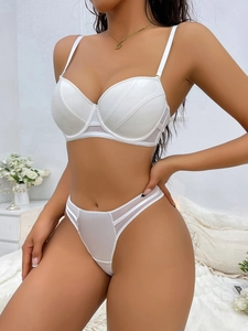 Detail of white satin lingerie set showing lace stitching and breathable mesh fabric